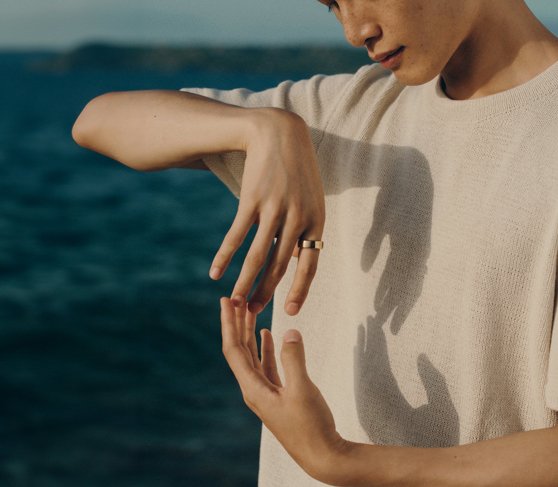 Woman wearing Oura Ring by a body of water