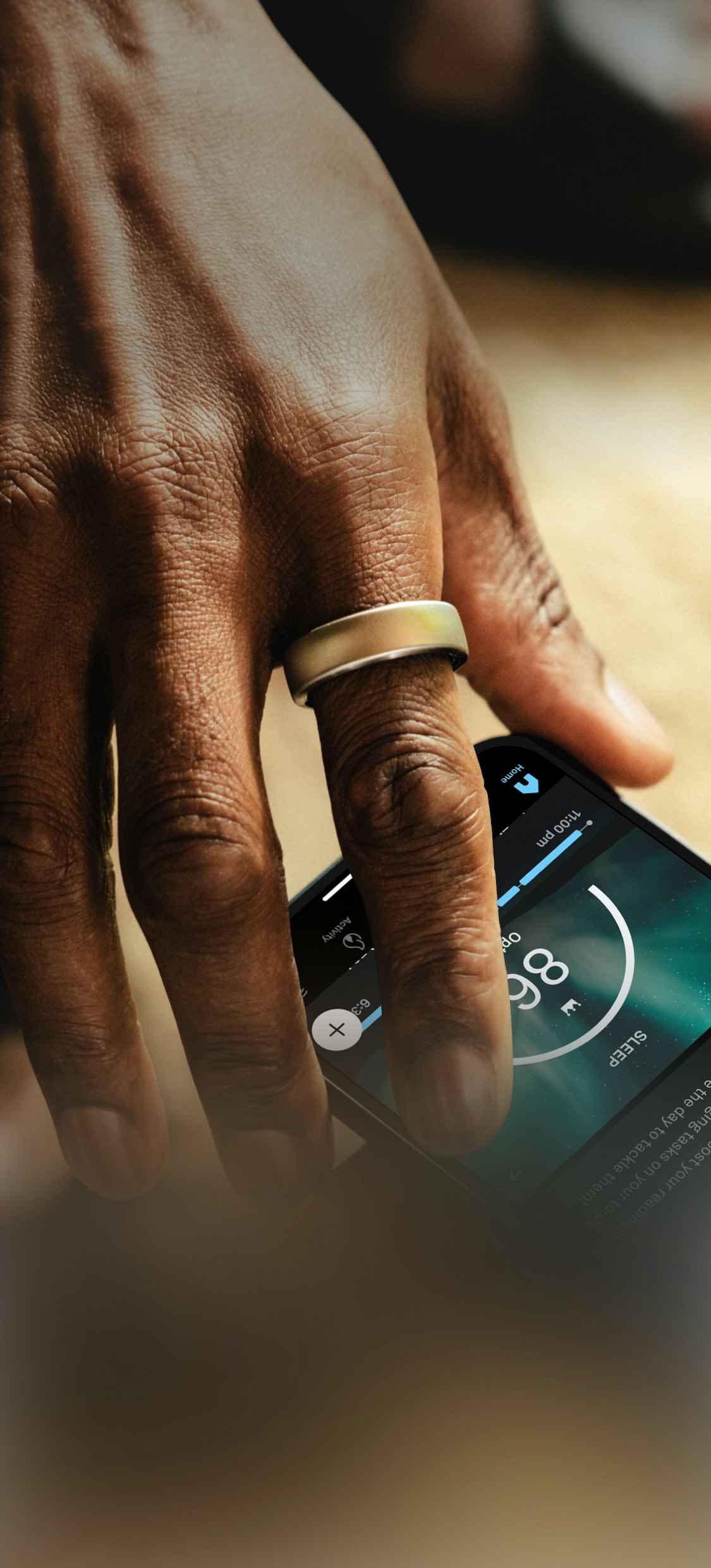 Oura Ring featured on a hand reaching for a mobile device with the Oura app open