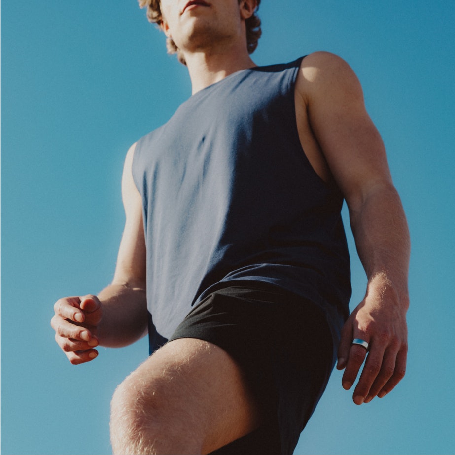 A man walking with an Oura ring on his index finger.