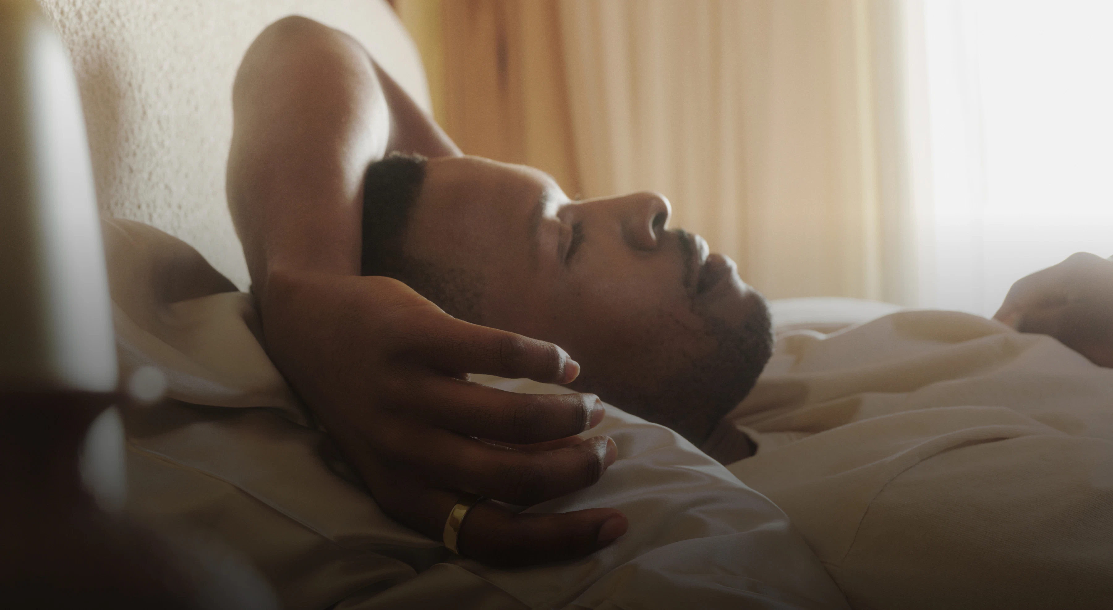 Man lying in bed wearing an Oura Ring 5