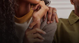 Person putting their hand on the shoulder of another person both wearing an Oura Ring 5