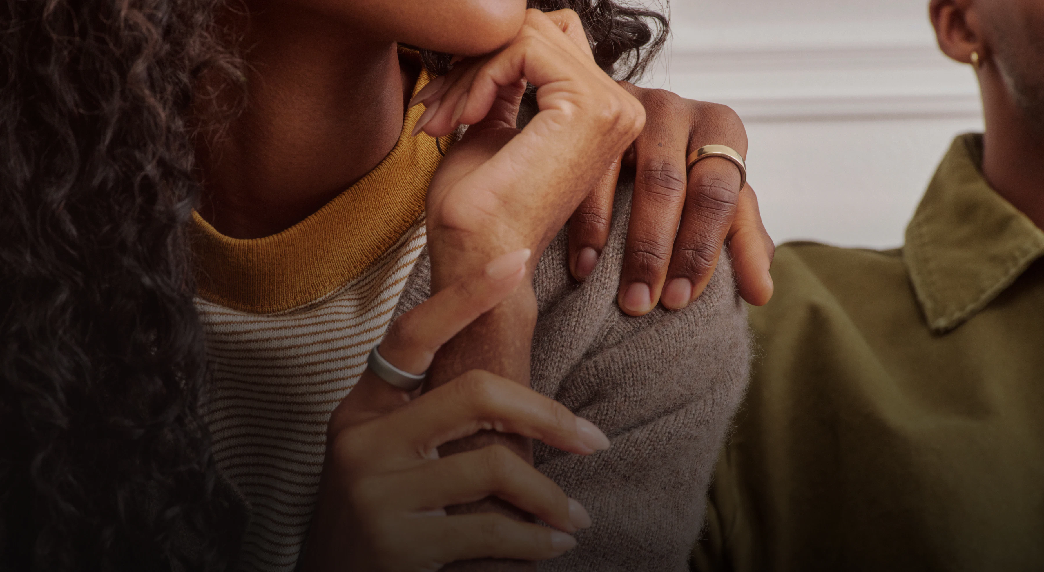 Person putting their hand on the shoulder of another person both wearing an Oura Ring 5