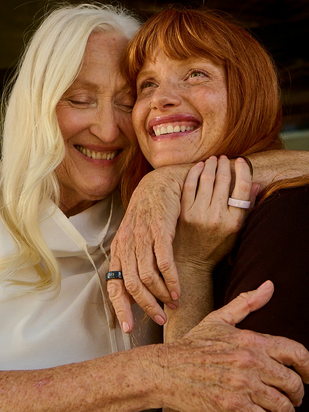 Two women hugging wearing Ceramic Oura Rings.