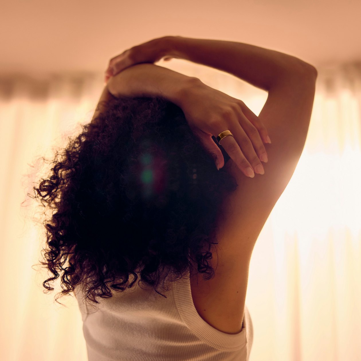 Woman wearing Oura ring stretching hands above head