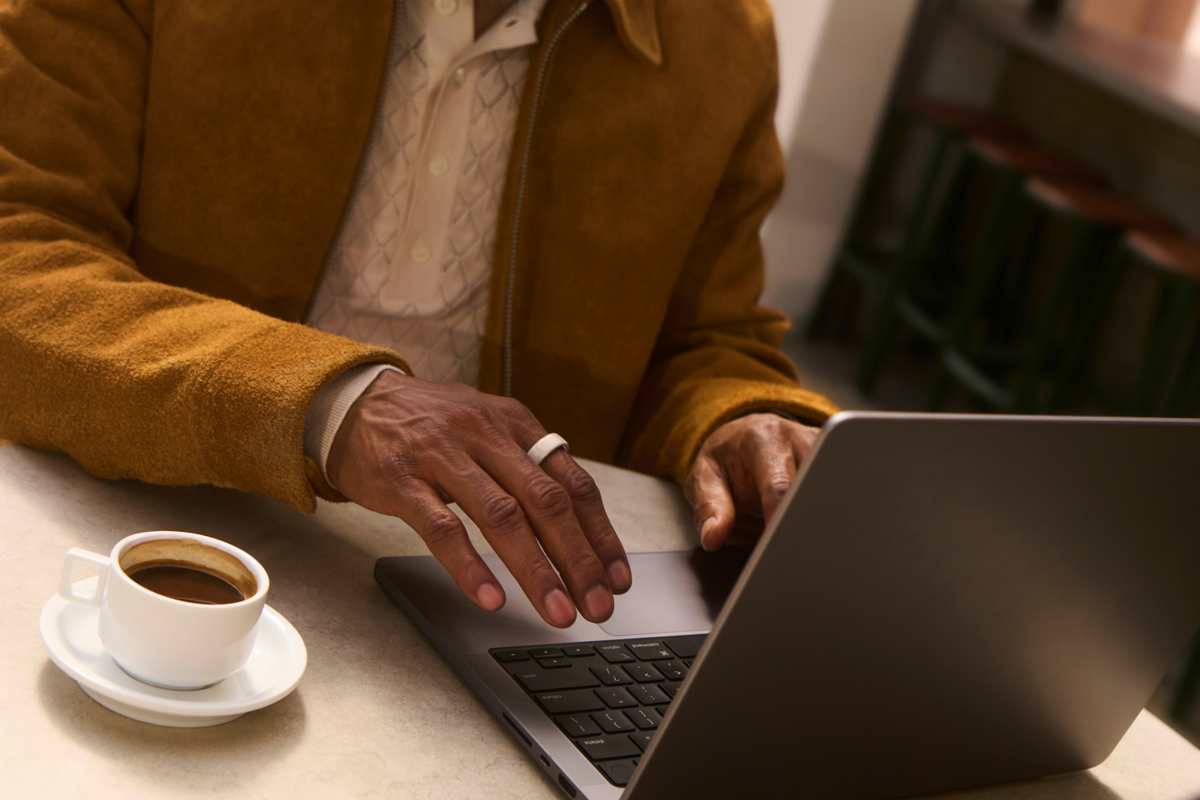 ノートパソコンで文字を入力しているOura Ringを着用した人物